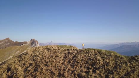 el dron orbita lentamente alrededor de un joven excursionista con una camisa amarilla en octubre