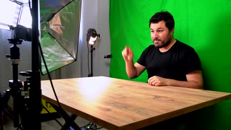 hombre vlogger grabando video de youtube en el estudio de pantalla verde de casa con cámara