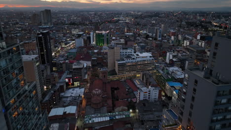 Aerial-view-between-high-rise,-over-the-cityscape-of-Bogota,-sunset-in-Colombia