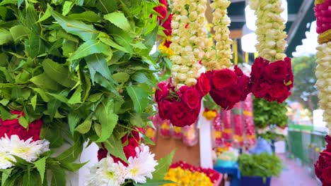 vibrant jasmine and rose garlands displayed at a bustling outdoor flower market in little india, singapore. bright daylight, smooth camera pan, rich colors