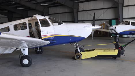small plane getting pulled out of hanger