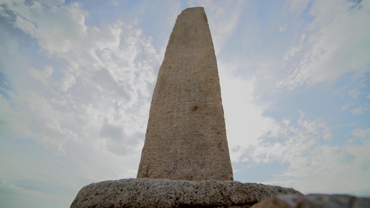 Ancien obélisque en pierre se dressant sur un ciel nuageux