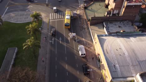 aerial shot of bus and cars overtaking homeless poor person with bike transporting plastic and dirt - indigent cartonero misery poverty in buenos aires