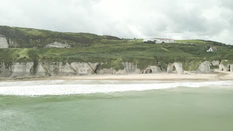 playa de rocas blancas - acantilados de piedra caliza cubiertos de hierba y playa de arena en irlanda del norte cerca de la ciudad de portrush