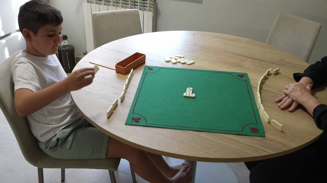 Pessoas jogando dominó em volta de uma mesa
