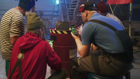 men engaged in online betting or trading on smartphones in a workshop