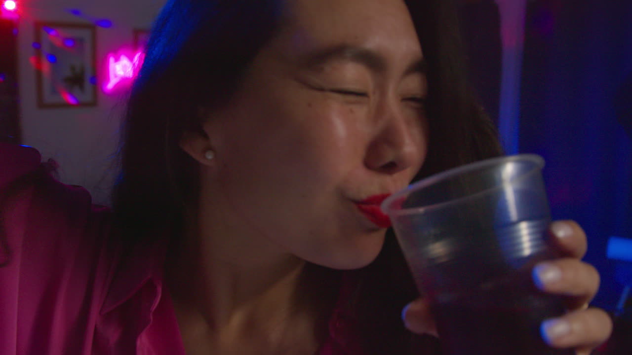 여자 가 집 파티 에서 춤 을 추고 술 을 마시는 것 을 즐기고 있다