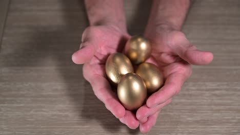 elderly man hands display a full handful of golden nest eggs from wealth planning and retirement budget needs