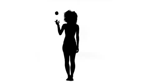 woman throwing and catching an apple in slow motion