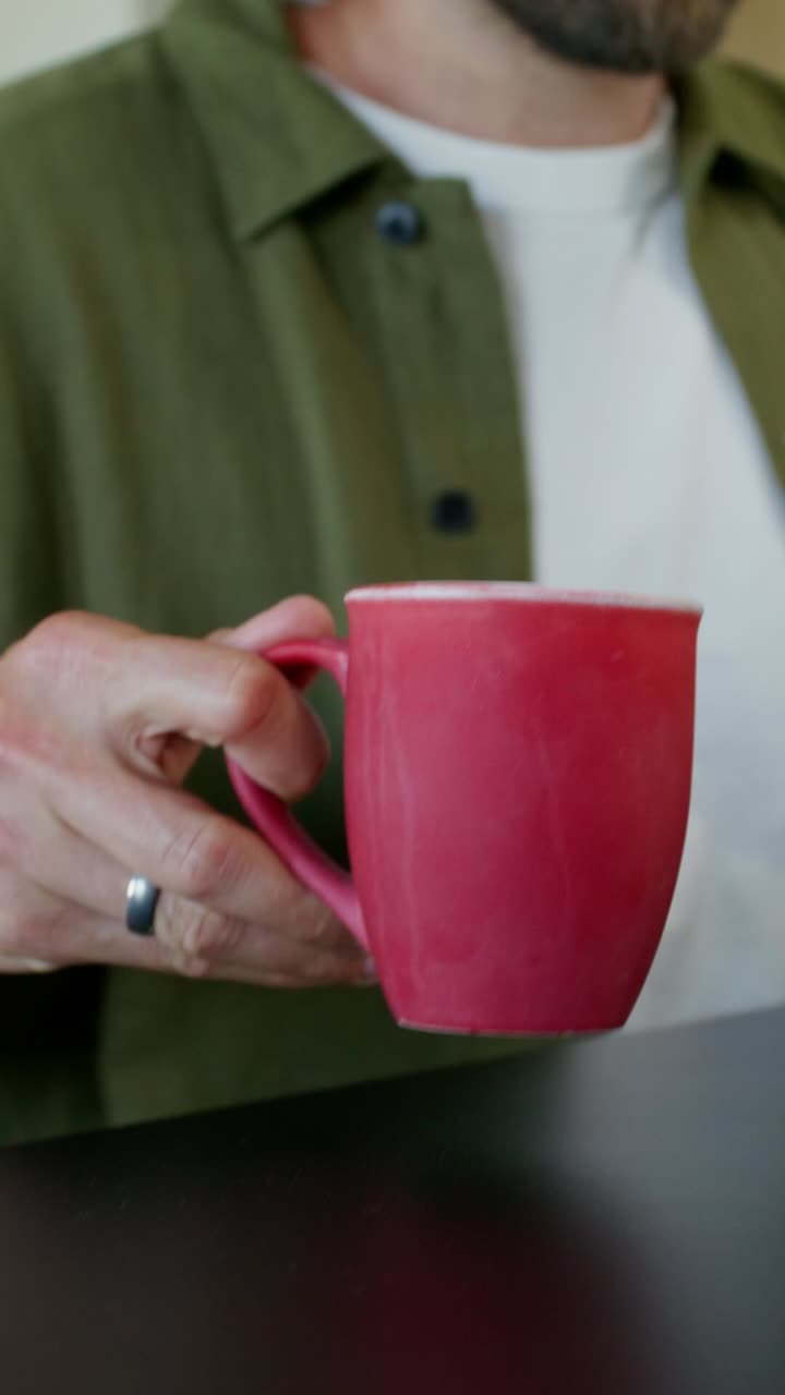 hombre sosteniendo una taza de café o té