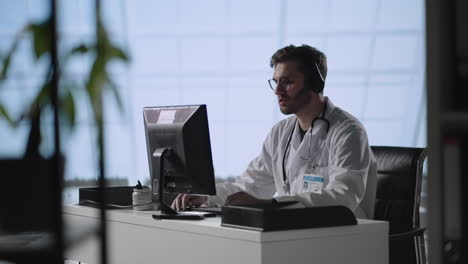 consulta médica en línea: el médico está haciendo una videollamada con un paciente. el profesional de la salud da consejos explicando los resultados de las pruebas. el joven médico centrado mantiene una videollamada en la computadora.