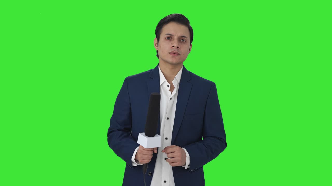 Indian reporter looking to the camera Green screen