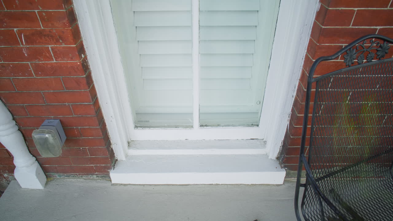 Gimbal shot of the outside of a window in a brick house