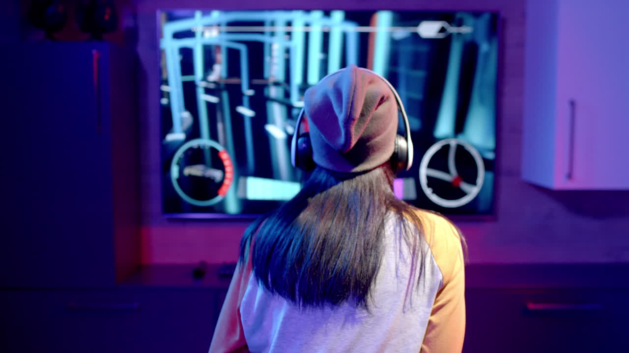 teenage girl wearing headphones playing video game on large screen in living room