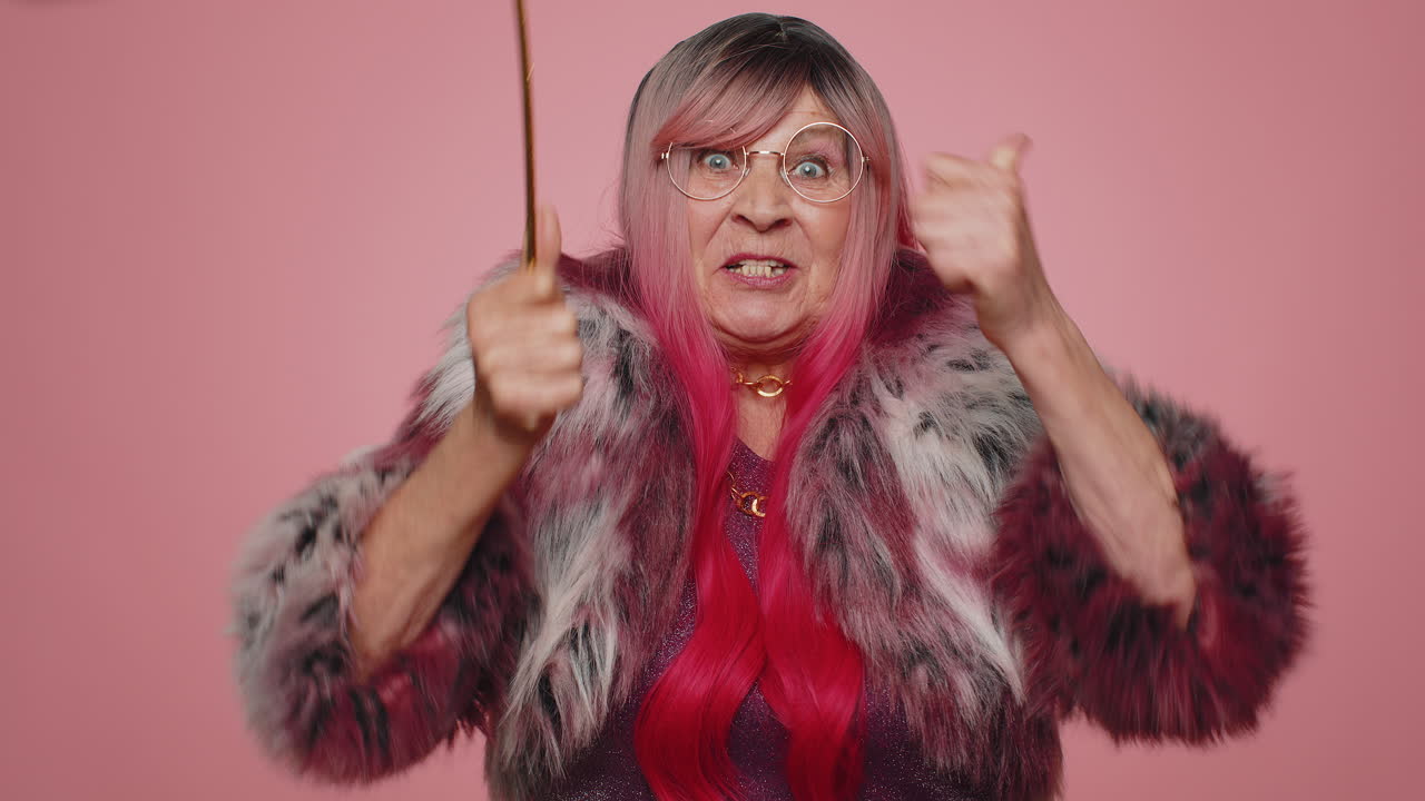 마법사 마법사 고령 여성이 마법 지 ⁇ 이로 몸짓을 하며 소원을 실현하고 마법사 주문을 던집니다.