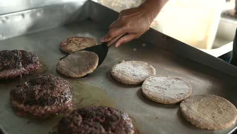 faceless chef with spatula turning hamburger buns cooking on hot surface