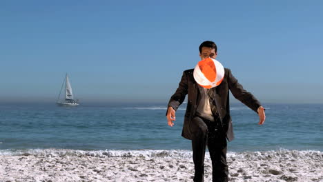 businessman playing on the beach with a balloon