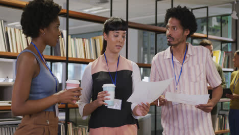 Diverse-male-and-female-business-colleagues-with-documents-discussing