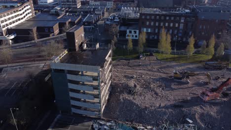 demolished multi storey car park concrete construction debris in town regeneration aerial right orbit view