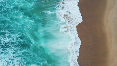 drone shot turquoise sea waves washing empty tropical beach. foamy ocean water.