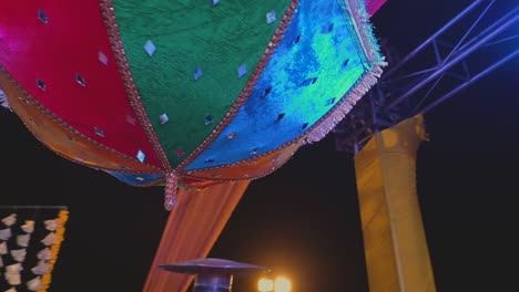 una impresionante toma de un paraguas colorido con un pequeño espejo en él utilizado como elemento de decoración en la celebración asiática
