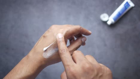 applying cream to a wound on the hand