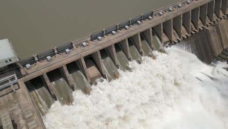 vista aérea de la represa hidroeléctrica que libera agua turbia de la inundación