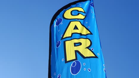 signo genérico de lavado de autos bandera ondeando en el viento en un día muy azul