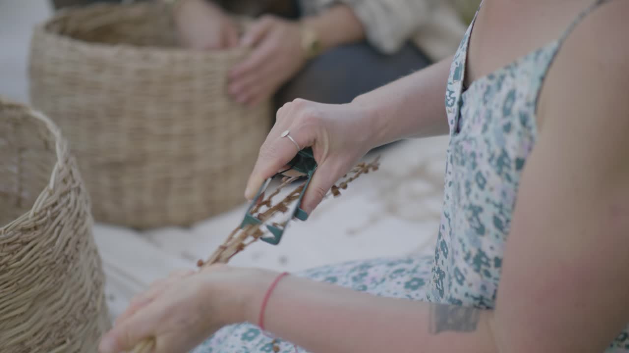 Handmade baskets and creative activity at Ne'ot Semadar, hands holding a toy frog and dried plant