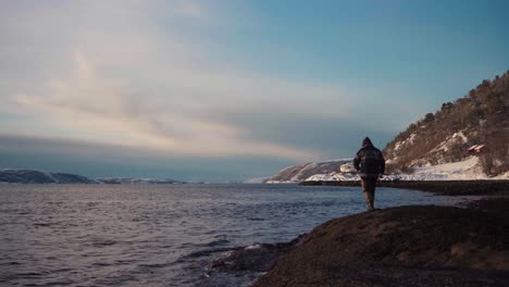 man went alone fishing, casting his fishing rod to the shore of trondheimsfjord, trondheim, norway