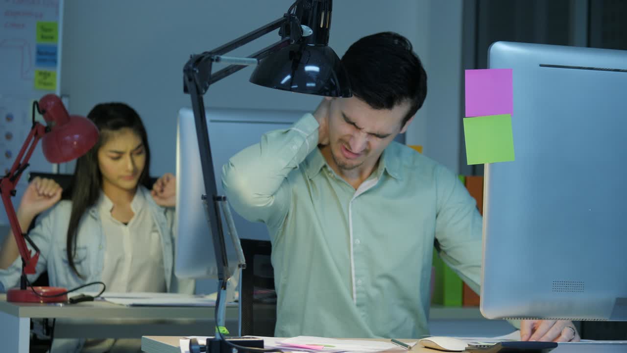 피곤하고 스트레스를 받는 사업가와 사업가 부부는 사무실에서 늦은 밤까지 일하고 있습니다.