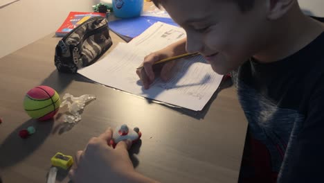 caucasian kid doing his schoolwork at home’s desk 4k