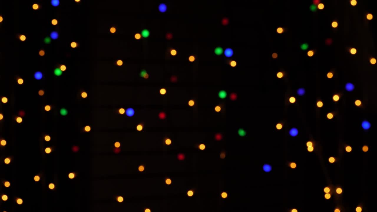 Abstract bokeh background in motion. shining, blurred multicolored particles, lights. bright bokeh from garlands on dark background. New year or Christmas festive backdrop