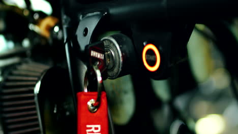 Man hand turn key to stop motorcycle engine. Key in starter keyhole