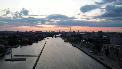 drone view moving forward at sunset in berlin germany view west along the river spree with badeschiff left and media spree right 4k