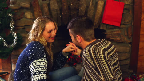 cute couple celebrating christmas together in front the fire