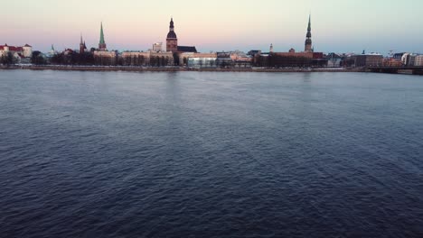 Daugava-river-water-surface-and-Riga-city-skyline,-aerial-view