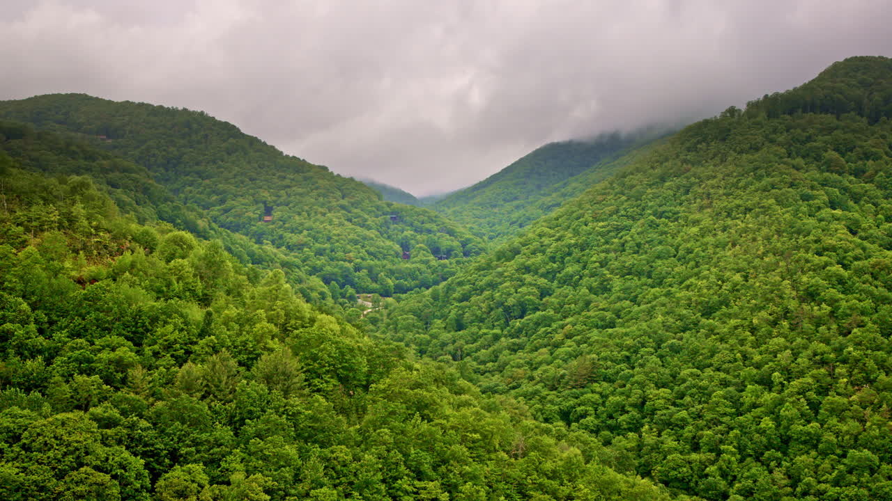 Cinematic drone glides above fog-wrapped ridgelines