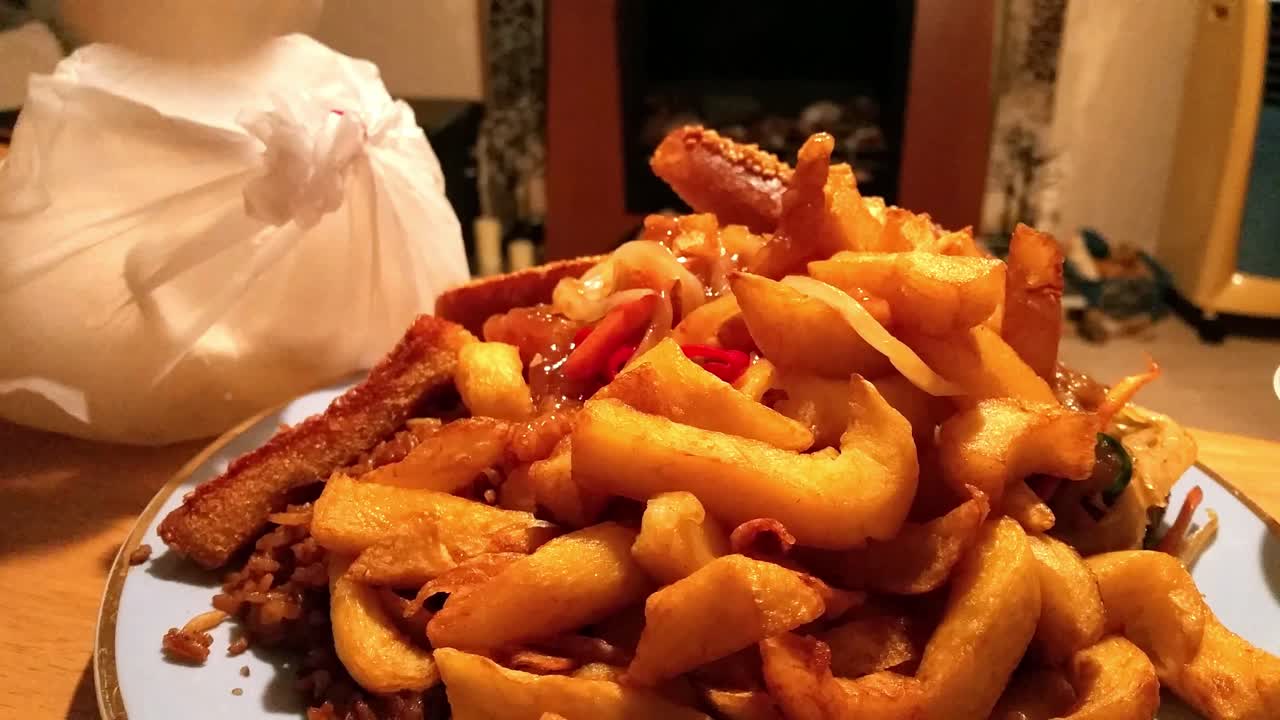 pedido de comida china para llevar, engorde, papas fritas grasientas e insalubres que quedan en el primer plano de la mesa en la sala de estar de la casa
