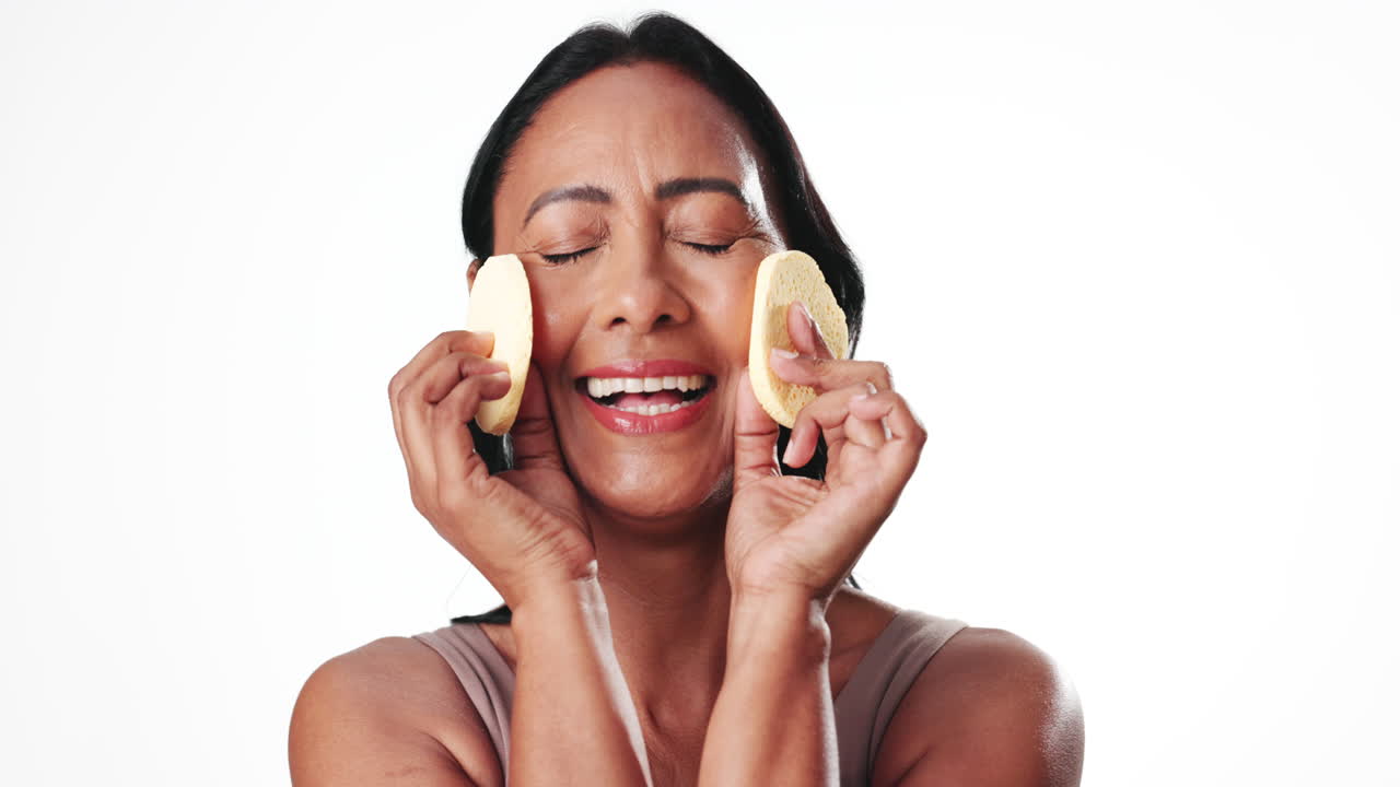 Happy Woman Enjoying a Facial Skincare Routine with Sponges