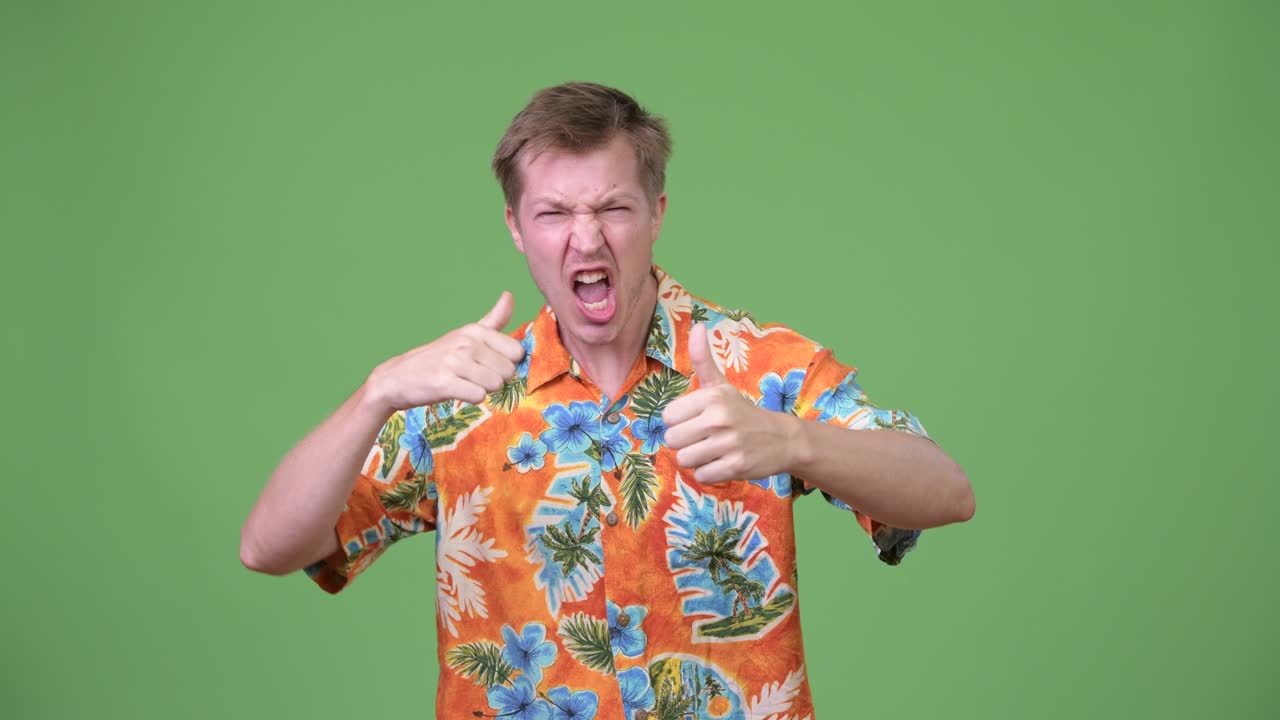 젊은 잘생긴 관광객이 엄지손가락을 들고