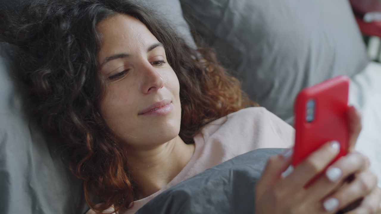 mujer usando el teléfono en la cama