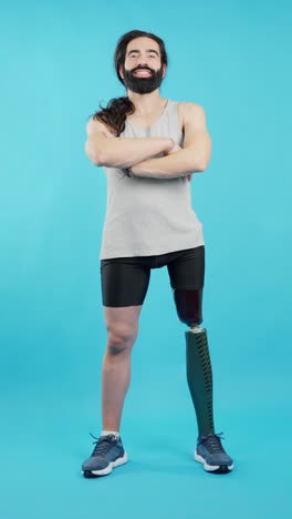 man with prosthetic leg standing confidently against a blue background