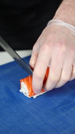 el chef preparando rollos de sushi de salmón