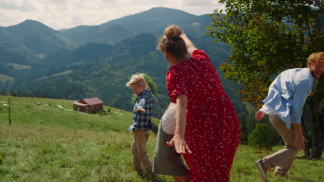 family running like plane on mountain meadow. funny people spreading hands wide.