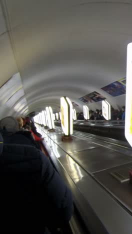 рјscalator at the metro station with crowd of people.