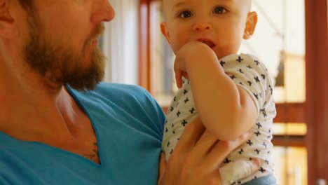 Father-holding-his-baby-boy-at-home-4k