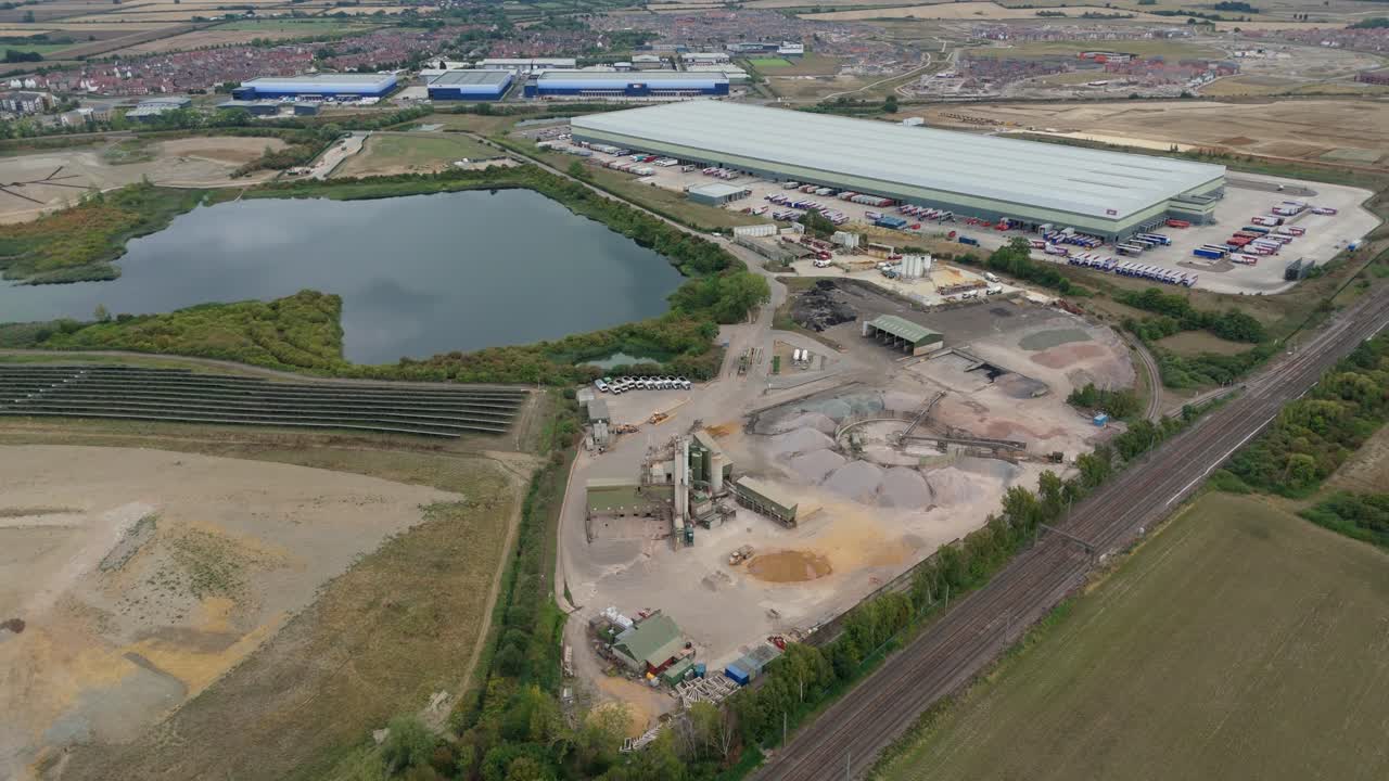 High angle aerial drone view of Bedford England industrial warehouses, solar rooftops and aggregates infrastructure in manufacturing landscape