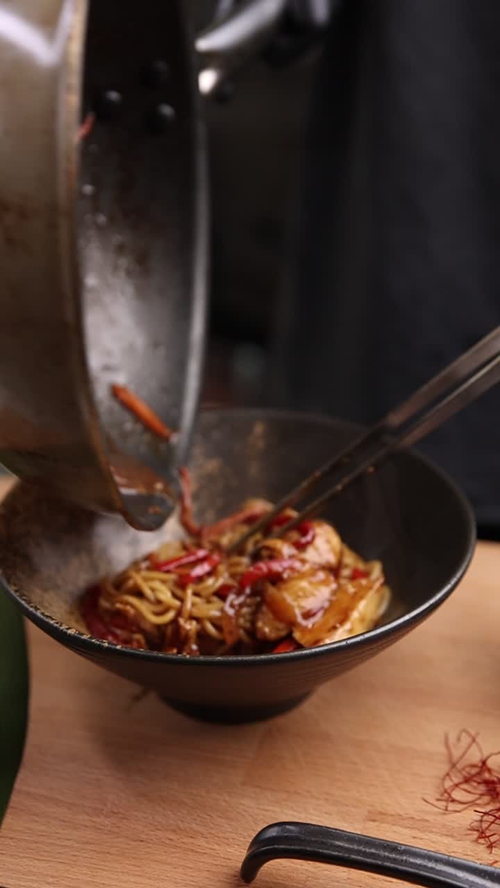 Servire deliziosi noodles asiatici con verdure da una padella calda