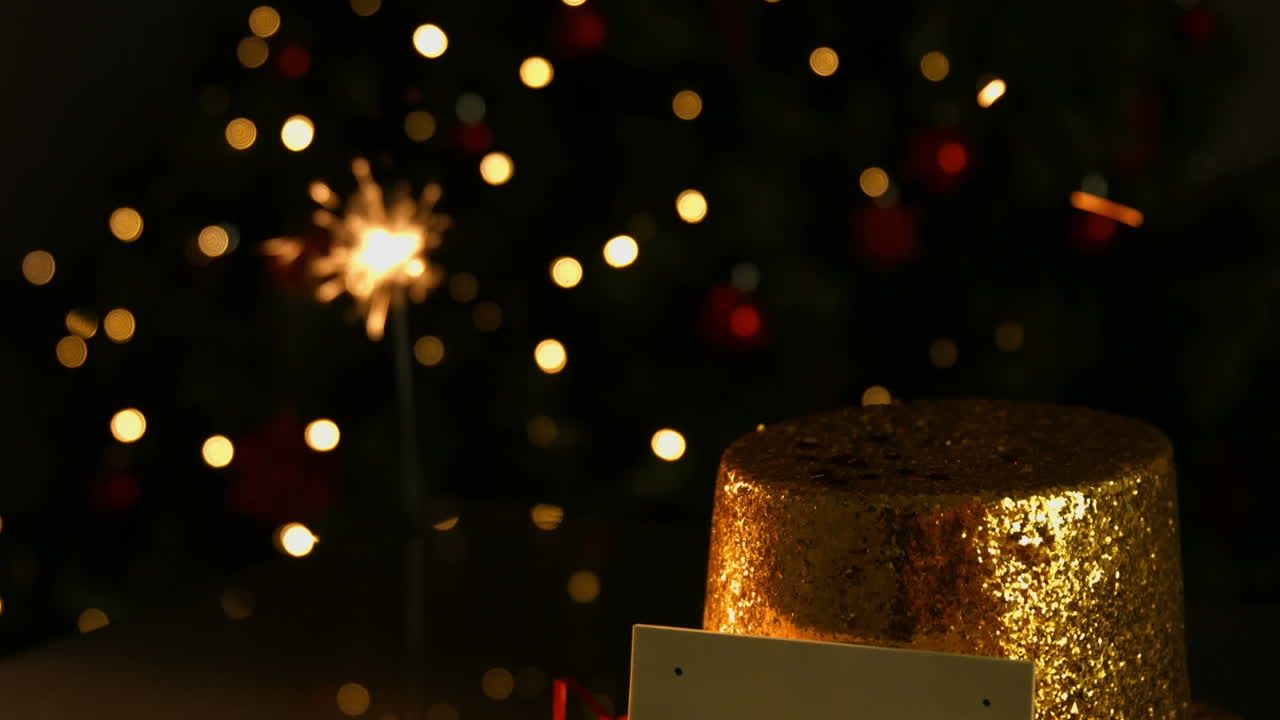 Animazione di stella filante, cappello di Natale e biglietto con spazio per il testo su macchie di luce arancioni.
